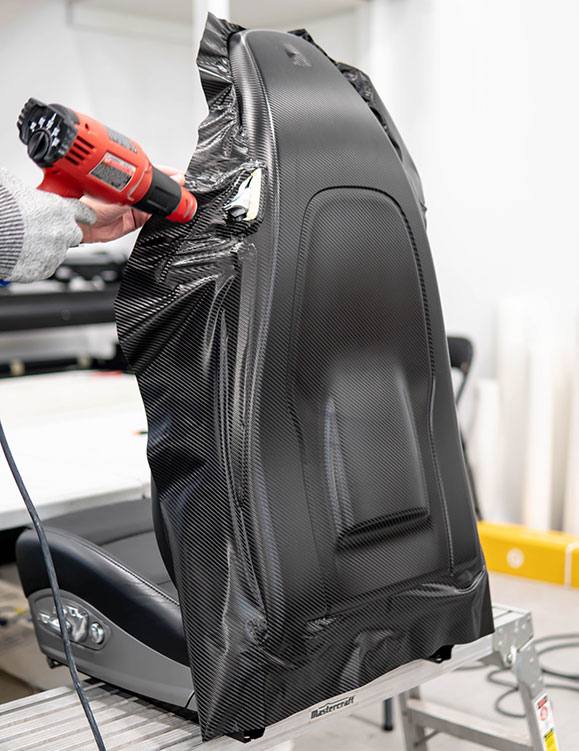 Car door panel being wrapped with carbon fiber vinyl